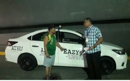 <p><strong>ABUSIVE TAXI.</strong> An airport authority (right) was able to intercept Eazy First taxi with plate number ACC 9310 near the Ninoy Aquino International Airport (NAIA) on Tuesday. The unit was brought to the impounding area at the Nayong Pilipino compound. Last Jan. 27, a food vlogger filed a complaint against the driver of this taxi unit, who charged a fare of PHP1,500 from NAIA terminal 3 to terminal 4. <em>(Photo courtesy of Manila International Airport Authority)</em></p>